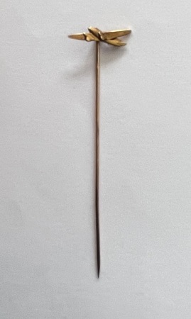 Petite boite contenant une épinglette dorée surmontée d'un avion. TB